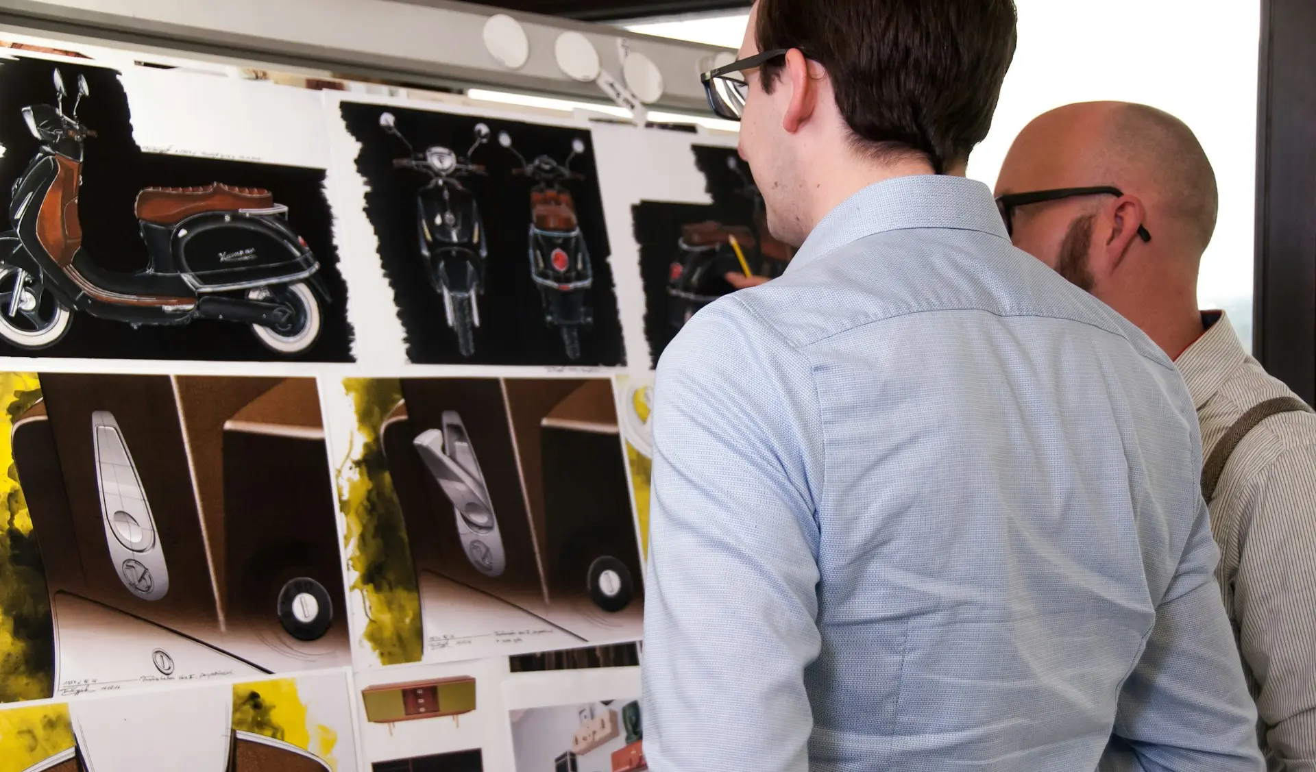 Hombre con camisa azul de vestir de pie junto a una estantería de madera blanca.